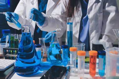 Bilimadamı laboratuarda tıbbi örnekleri mikro plakaya yerleştiriyor.