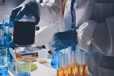 Bilimadamı laboratuarda tıbbi örnekleri mikro plakaya yerleştiriyor.