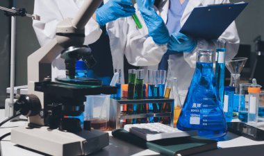 Bilimadamı laboratuarda tıbbi örnekleri mikro plakaya yerleştiriyor.