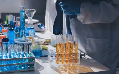 Bilimadamı laboratuarda tıbbi örnekleri mikro plakaya yerleştiriyor.