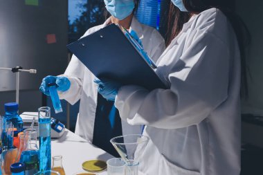 Bilimadamı laboratuarda tıbbi örnekleri mikro plakaya yerleştiriyor.