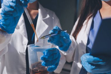 Bilimadamı laboratuarda tıbbi örnekleri mikro plakaya yerleştiriyor.