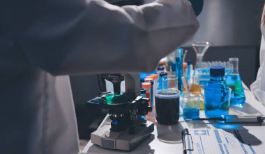 Bilimadamı laboratuarda tıbbi örnekleri mikro plakaya yerleştiriyor.