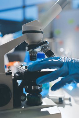 Bilimadamı laboratuarda tıbbi örnekleri mikro plakaya yerleştiriyor.