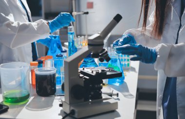 Bilimadamı laboratuarda tıbbi örnekleri mikro plakaya yerleştiriyor.