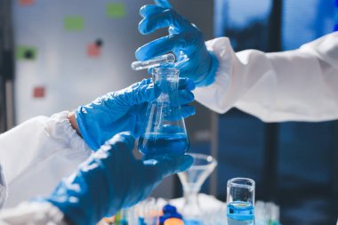 Bilimadamı laboratuarda tıbbi örnekleri mikro plakaya yerleştiriyor.