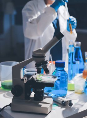 Bilimadamı laboratuarda tıbbi örnekleri mikro plakaya yerleştiriyor.