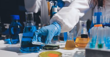 Bilimadamı laboratuarda tıbbi örnekleri mikro plakaya yerleştiriyor.