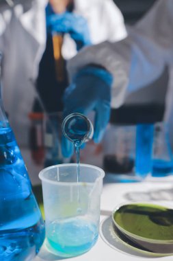 Bilimadamı laboratuarda tıbbi örnekleri mikro plakaya yerleştiriyor.