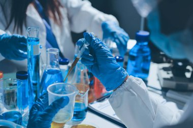 Bilimadamı laboratuarda tıbbi örnekleri mikro plakaya yerleştiriyor.