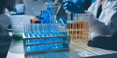 Bilimadamı laboratuarda tıbbi örnekleri mikro plakaya yerleştiriyor.