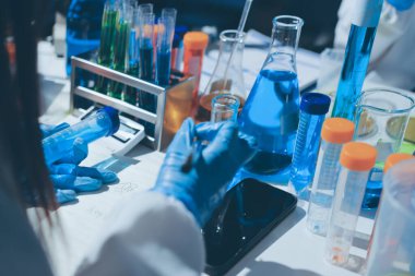 Bilimadamı laboratuarda tıbbi örnekleri mikro plakaya yerleştiriyor.