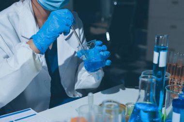 Bilimadamı laboratuarda tıbbi örnekleri mikro plakaya yerleştiriyor.