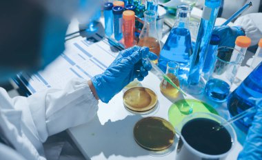 Bilimadamı laboratuarda tıbbi örnekleri mikro plakaya yerleştiriyor.