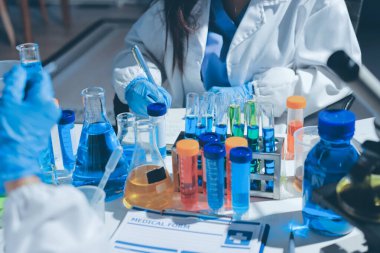 Bilimadamı laboratuarda tıbbi örnekleri mikro plakaya yerleştiriyor.