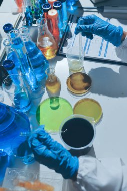 Bilimadamı laboratuarda tıbbi örnekleri mikro plakaya yerleştiriyor.