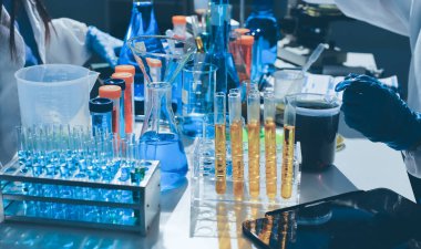 Bilimadamı laboratuarda tıbbi örnekleri mikro plakaya yerleştiriyor.