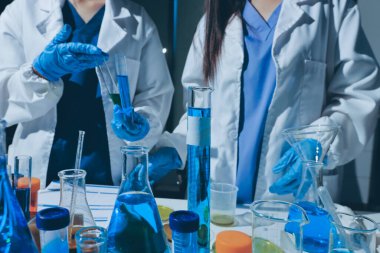 Bilimadamı laboratuarda tıbbi örnekleri mikro plakaya yerleştiriyor.