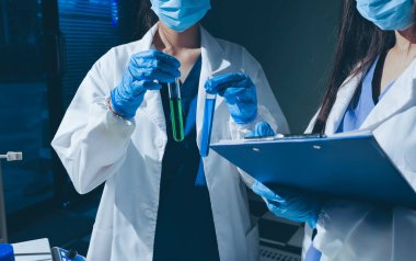 Bilimadamı laboratuarda tıbbi örnekleri mikro plakaya yerleştiriyor.