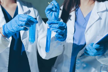 Bilimadamı laboratuarda tıbbi örnekleri mikro plakaya yerleştiriyor.