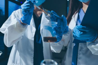 Bilimadamı laboratuarda tıbbi örnekleri mikro plakaya yerleştiriyor.