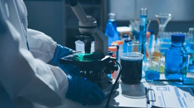 Bilimadamı laboratuarda tıbbi örnekleri mikro plakaya yerleştiriyor.