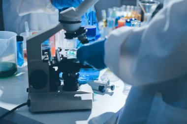 Bilimadamı laboratuarda tıbbi örnekleri mikro plakaya yerleştiriyor.