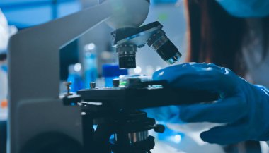 Bilimadamı laboratuarda tıbbi örnekleri mikro plakaya yerleştiriyor.