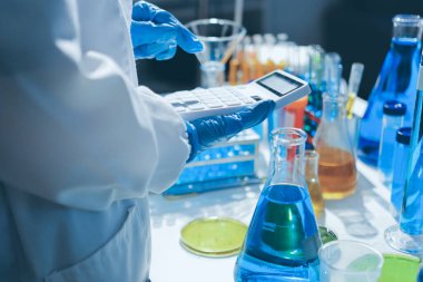 Bilimadamı laboratuarda tıbbi örnekleri mikro plakaya yerleştiriyor.