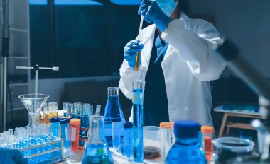 Bilimadamı laboratuarda tıbbi örnekleri mikro plakaya yerleştiriyor.