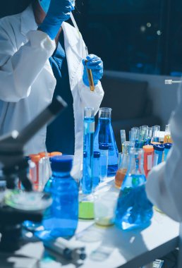 Bilimadamı laboratuarda tıbbi örnekleri mikro plakaya yerleştiriyor.