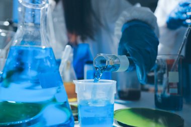 Bilimadamı laboratuarda tıbbi örnekleri mikro plakaya yerleştiriyor.