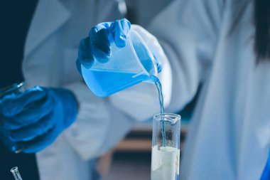 Bilimadamı laboratuarda tıbbi örnekleri mikro plakaya yerleştiriyor.