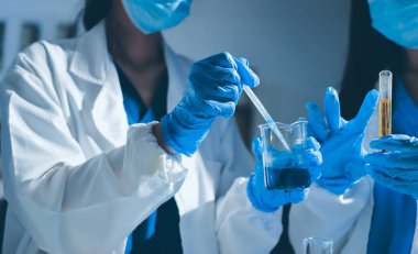 Bilimadamı laboratuarda tıbbi örnekleri mikro plakaya yerleştiriyor.