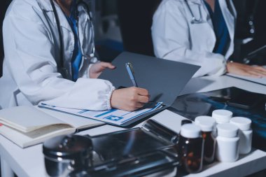 Erkek ve kadın doktorlar bir hastane odasında toplantı yapıyorlar..