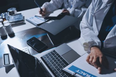 Erkek ve kadın doktorlar bir hastane odasında toplantı yapıyorlar..