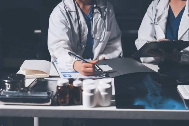 Erkek ve kadın doktorlar bir hastane odasında toplantı yapıyorlar..