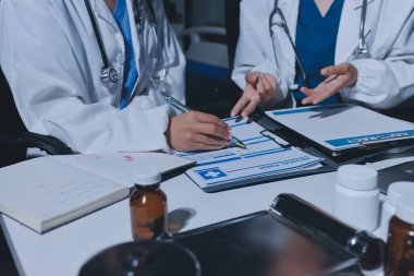 Erkek ve kadın doktorlar bir hastane odasında toplantı yapıyorlar..