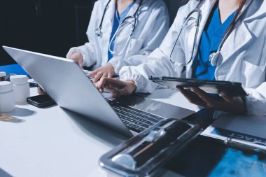 Erkek ve kadın doktorlar bir hastane odasında toplantı yapıyorlar..