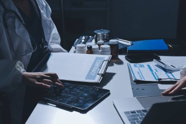 Erkek ve kadın doktorlar bir hastane odasında toplantı yapıyorlar..