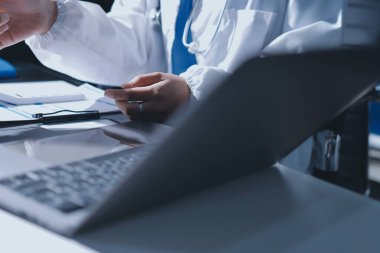 Erkek ve kadın doktorlar bir hastane odasında toplantı yapıyorlar..