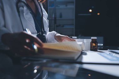 Erkek ve kadın doktorlar bir hastane odasında toplantı yapıyorlar..