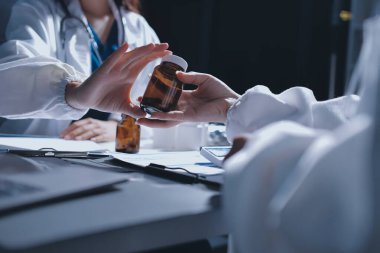 Erkek ve kadın doktorlar bir hastane odasında toplantı yapıyorlar..