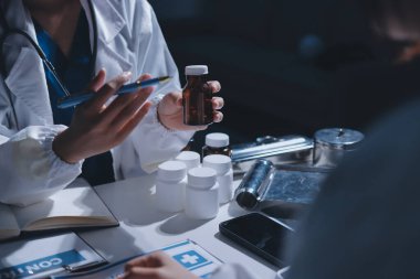 Erkek ve kadın doktorlar bir hastane odasında toplantı yapıyorlar..