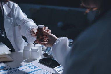 Erkek ve kadın doktorlar bir hastane odasında toplantı yapıyorlar..