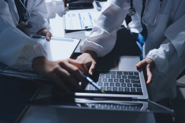 Erkek ve kadın doktorlar bir hastane odasında toplantı yapıyorlar..