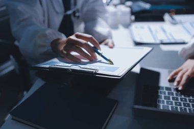 Erkek ve kadın doktorlar bir hastane odasında toplantı yapıyorlar..