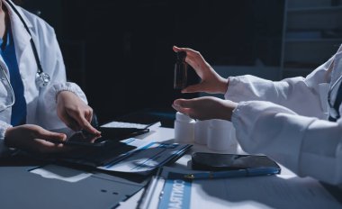 Erkek ve kadın doktorlar bir hastane odasında toplantı yapıyorlar..