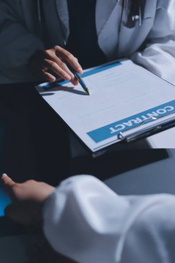 Erkek ve kadın doktorlar bir hastane odasında toplantı yapıyorlar..