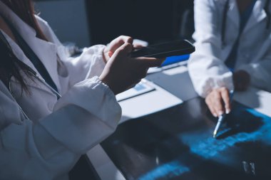 Erkek ve kadın doktorlar bir hastane odasında toplantı yapıyorlar..